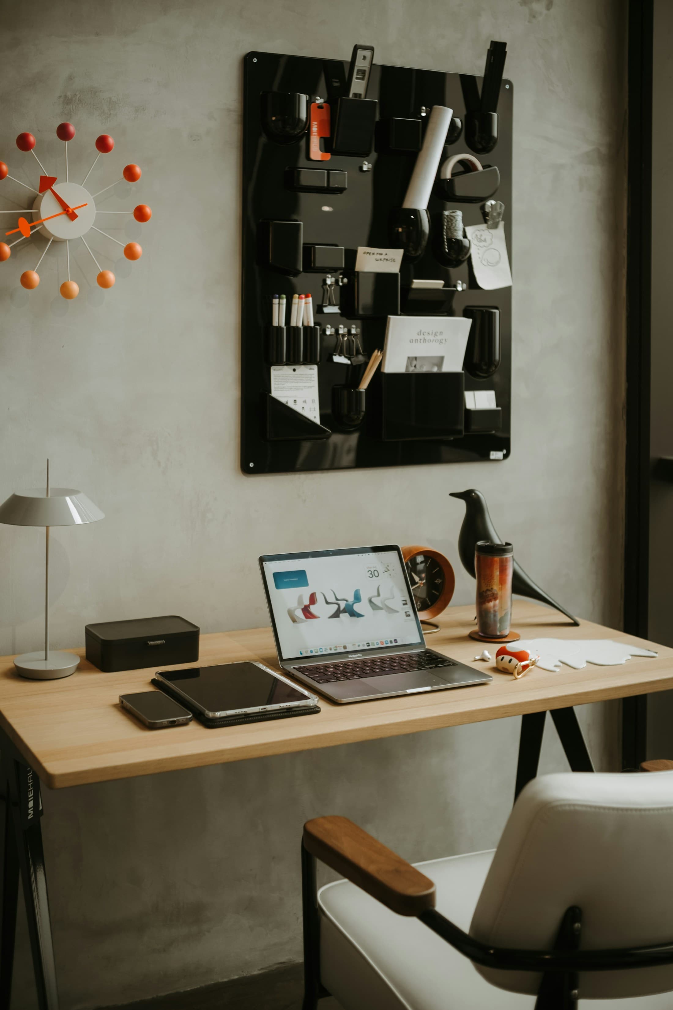 A considered desk with organized tools, devices, notes, and warm task lighting.